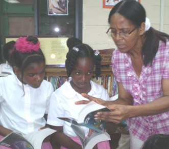 Third-grade teacher Tyree Knight helps Brianna Henry, left, and T'Chell Isles explore their new dictionaries.