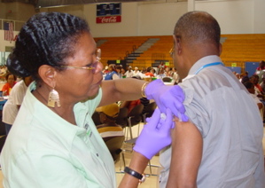 Dr. Cora Christian vaccinates Dr. Alfred Heath Thursday at CareForce.