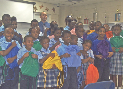 Proud Lockhart students gather to display their new backpacks. In the background is DOE Insular Superintendent Joseph Sibilly. 