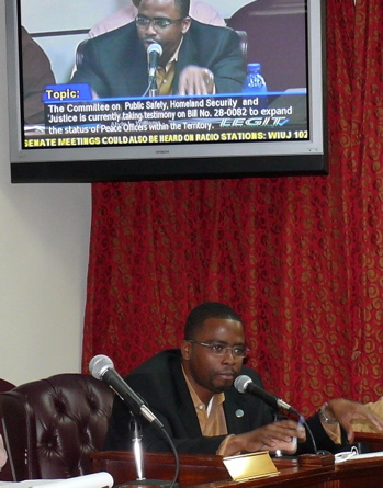 Sen. Alvin Williams argues in favor of the bill while his televised image is shown above him.