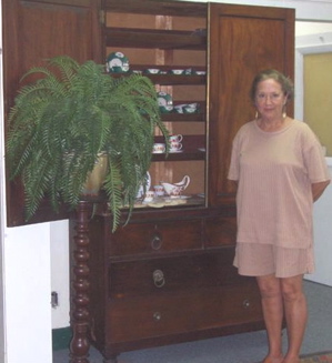 Debbie Avery, director of the St. Thomas Historical Trust Museum, with an antique cabinet in the museum.