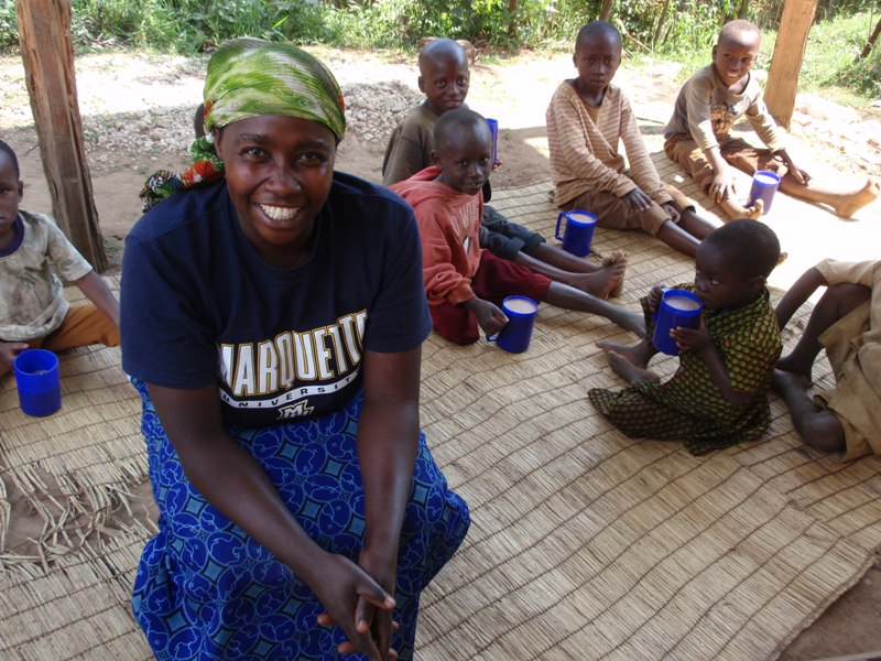 Jacqueline smiling joyously as she makes porridge.