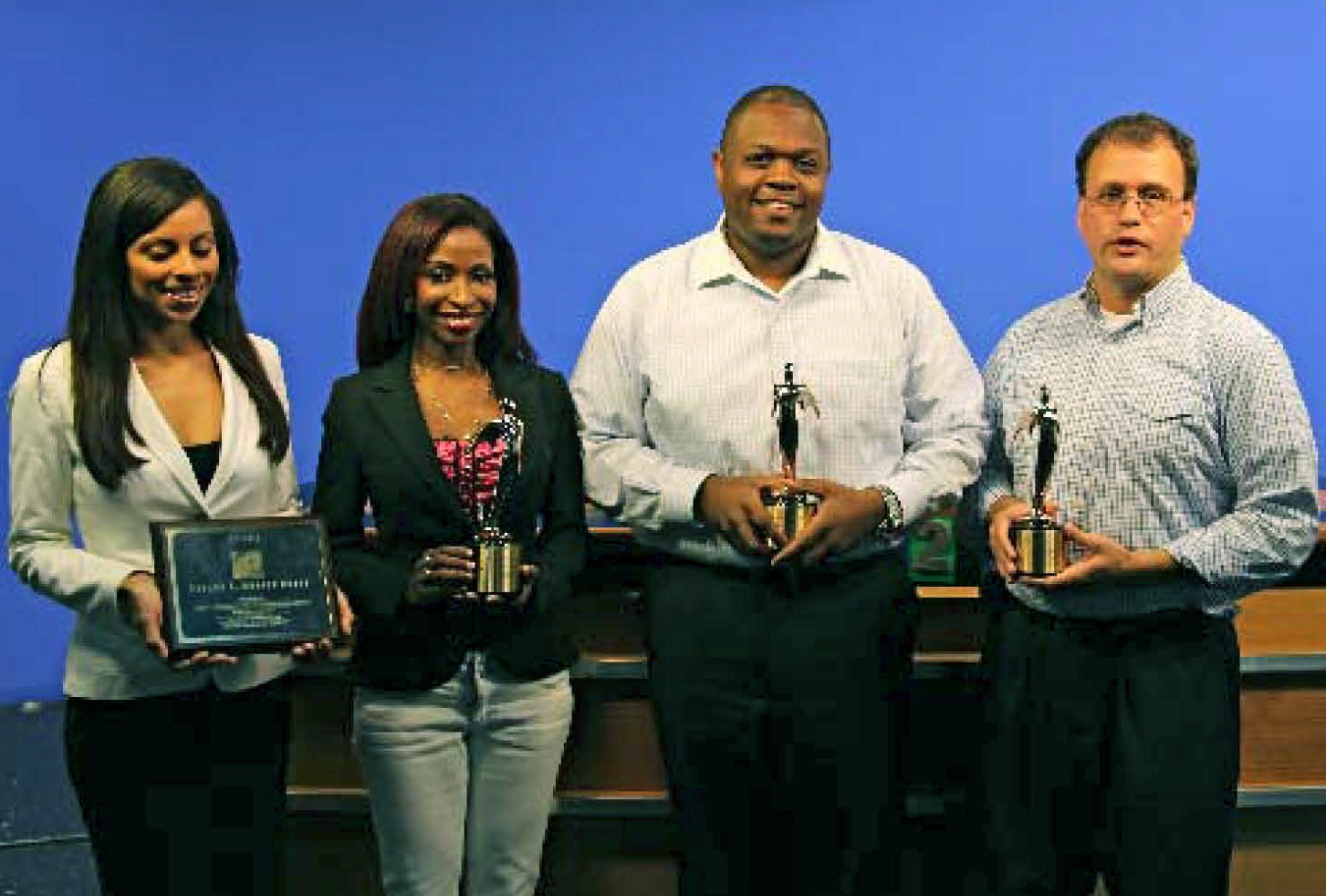 From left, Allison Bourne-Vanneck, Sandra Goomansingh, Netfa Romain and TV2 General Manager Brent Butler display their national awards Tuesday.