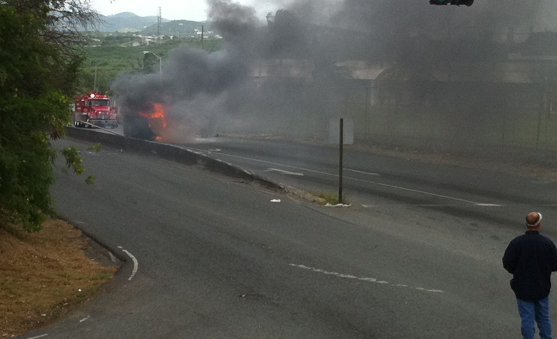 Smoke pours from the overturned Mitsubishi on Melvin Evans Highway. Remarkable there were no serious injuries.