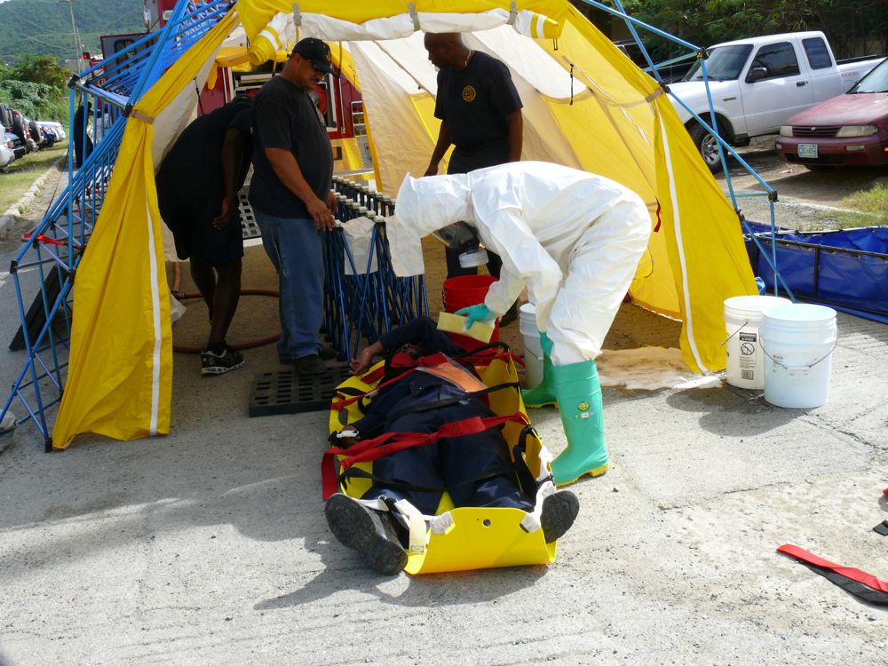 WAPA employee Rubio Heywood, "injured" in a mock chlorine spill, is decontaminated by V.I. Fire Services hazmat specialist Okeshia Iles.