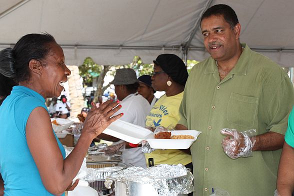 Gov. John deJongh Jr. fixes a plate of food for Edris Canonier during Thursday's event.