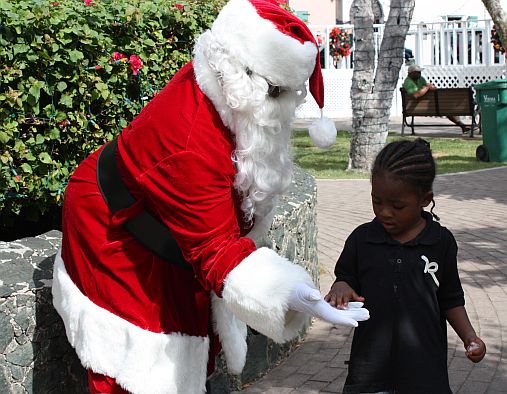 Three-year-old Shiyan Gumbs gets a treat from Santa. 