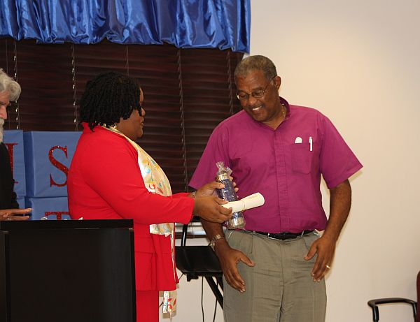 Bishop Ambrose Gumbs gets his certificate from Human Services Program Coordinator Clarissa Warrington.
