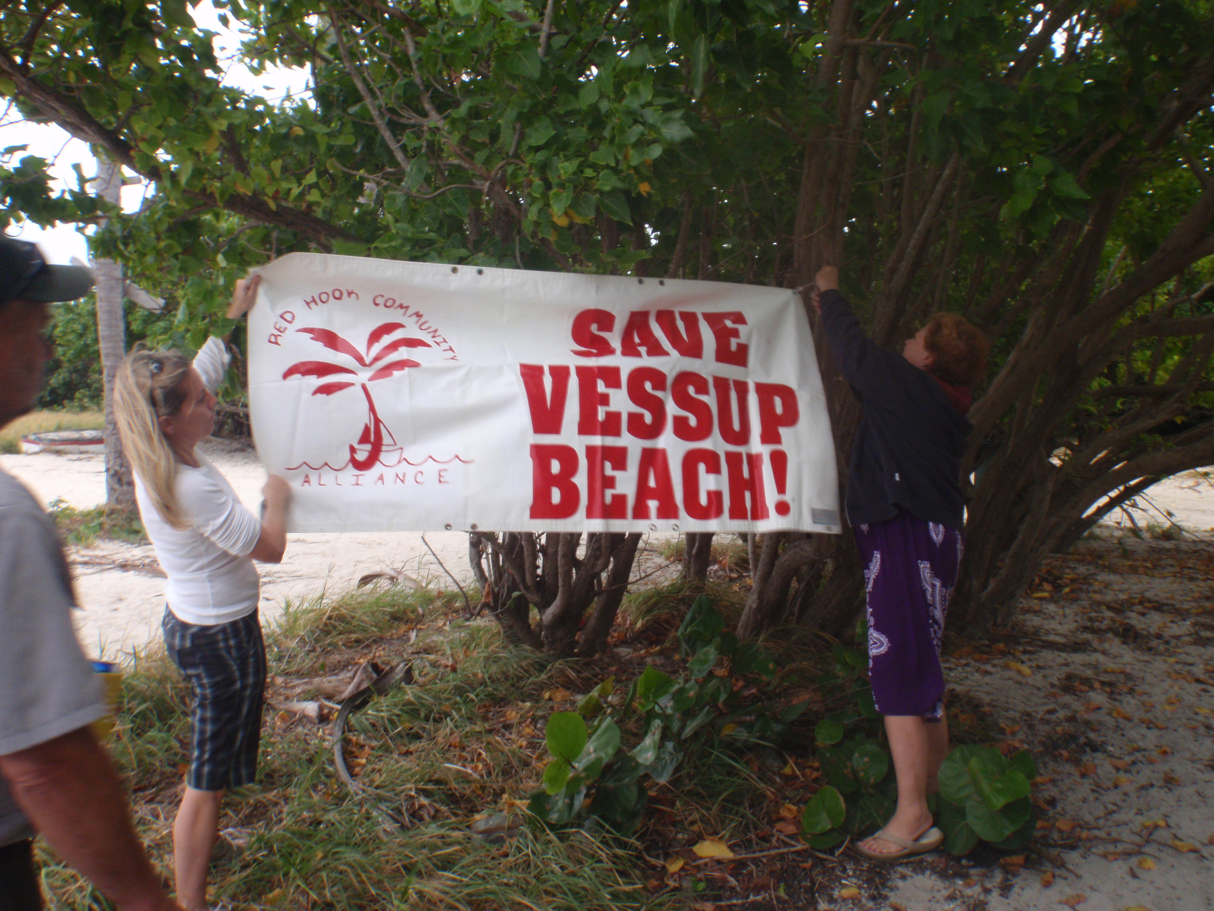 Red Hook Community Alliance founder Andrea King (left) helps unfurl the group's banner.