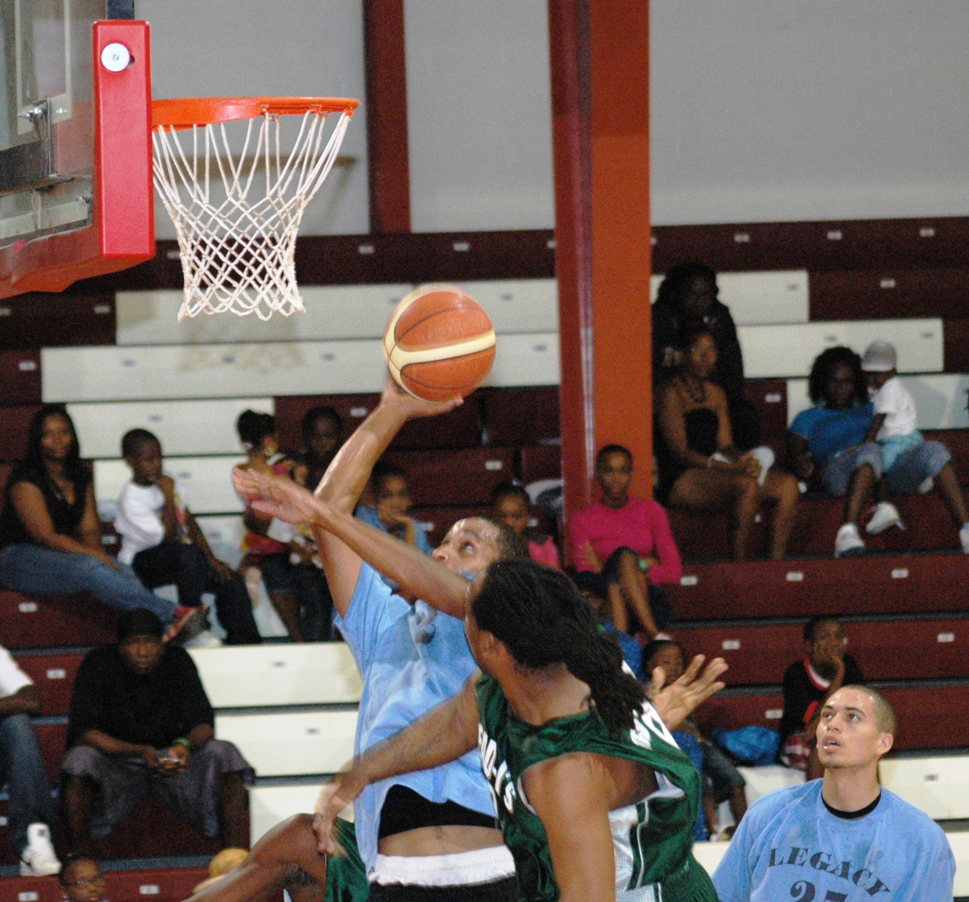 Legacy's Chris Sealy is hammered by Dread I's Rudolf Simmonds on a drive to the basket.