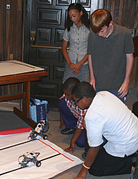STEM students Torhera Durand (clockwise from top), John Paulus, Darryl Donohue Jr. and Cedric Patton set up robots  at Friday's close.