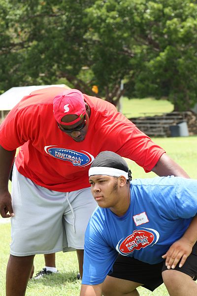 NFL offensive lineman Robert Hicks (left) pushes Ivanna Eudora Kean High School student Akram Solomon through his training.