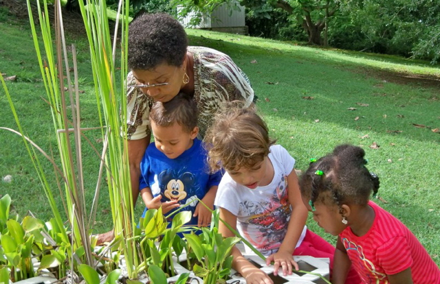 Sylvia Sullivan, head instructor at the St. Croix Montessori School, with students at the school's pond.