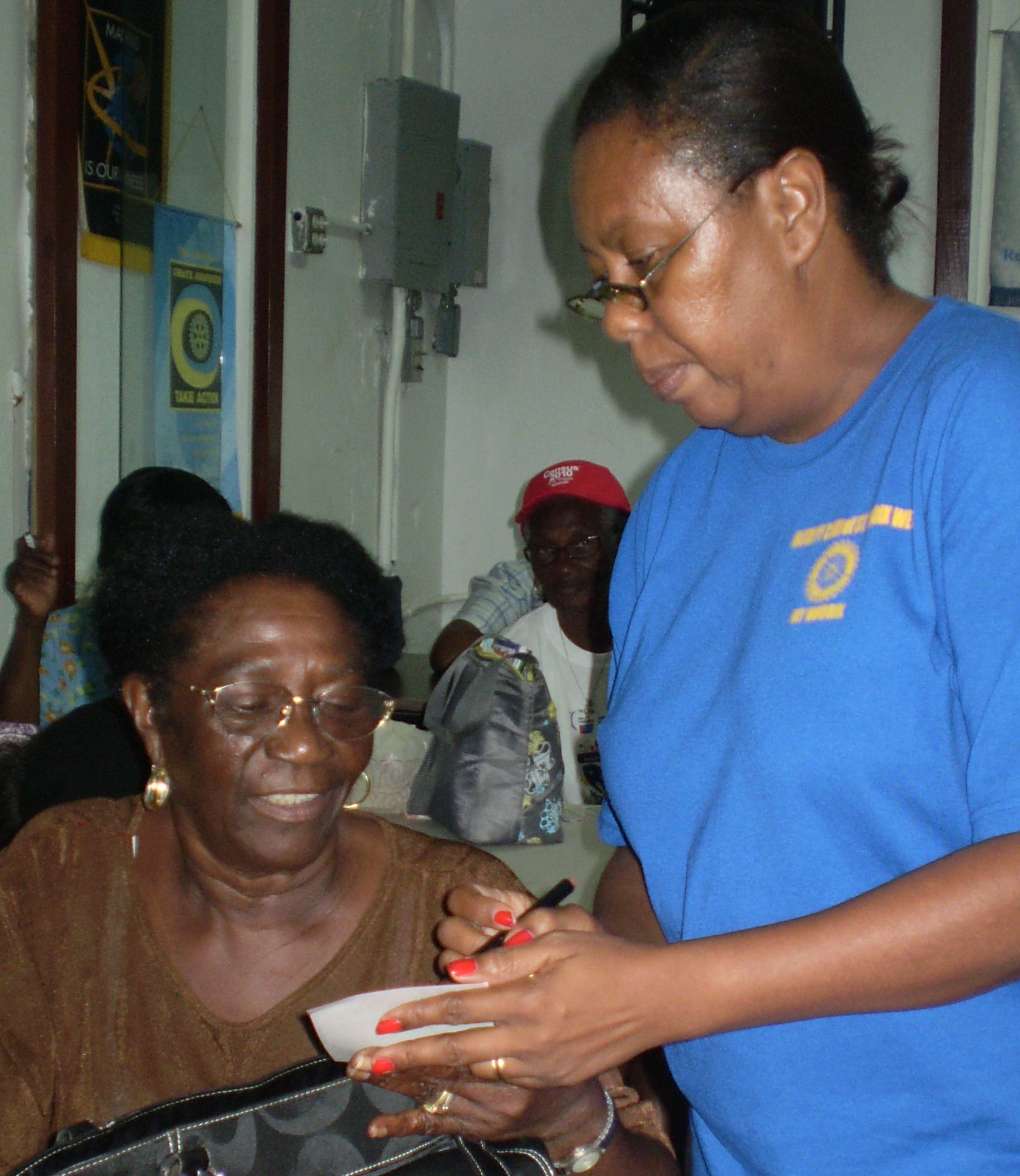 Rotary President Deborah Howell (right) checking Marcelle Sorhaindo's bingo card.