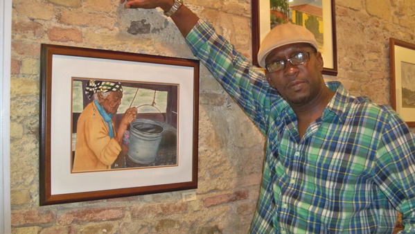 Elwin Joseph with his painting, ‘Hard at Work.’