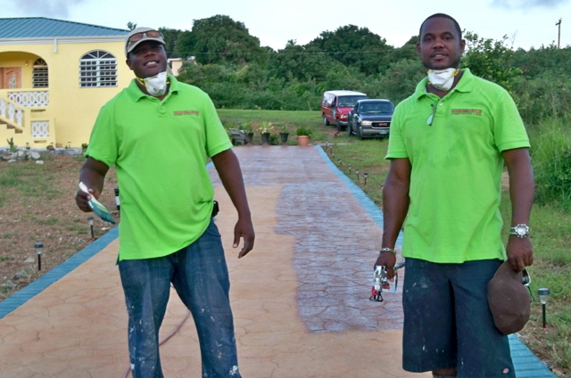 Jermaine McFarlane, left, and Crispin Victor work on a driveway in Hermon Hill.