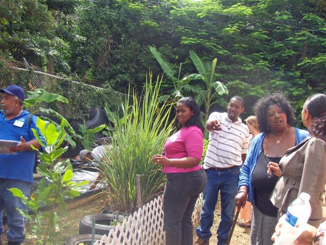 Vincent Henley (center) points out features in the Gladys Abraham School garden.