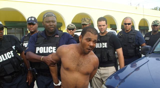 A cuffed Edward Encarnacion is led into the police station after his arrest Tuesday (Photo courtesy Melody Rames, VIPD.)