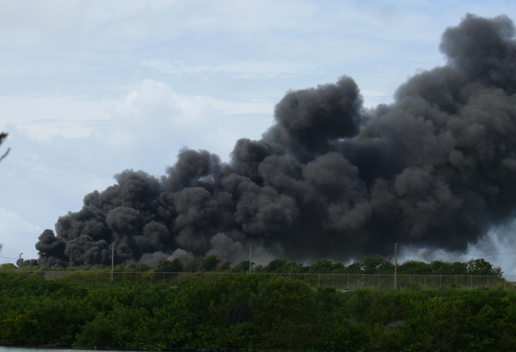 A massive, billowing cloud of black smoke pours into the air above the Hovensa refinery.