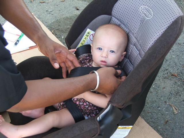 An infant is fitted in a child safety seat during a VIPD event last week.