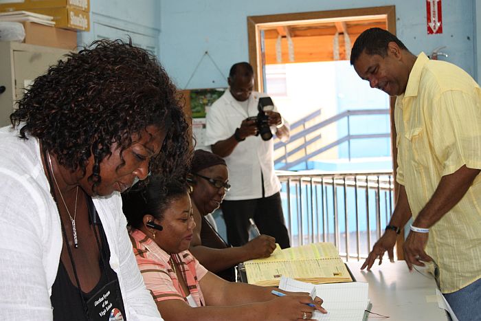 Gov. John deJongh Jr. signs in to vote at Charlotte Amalie High School.