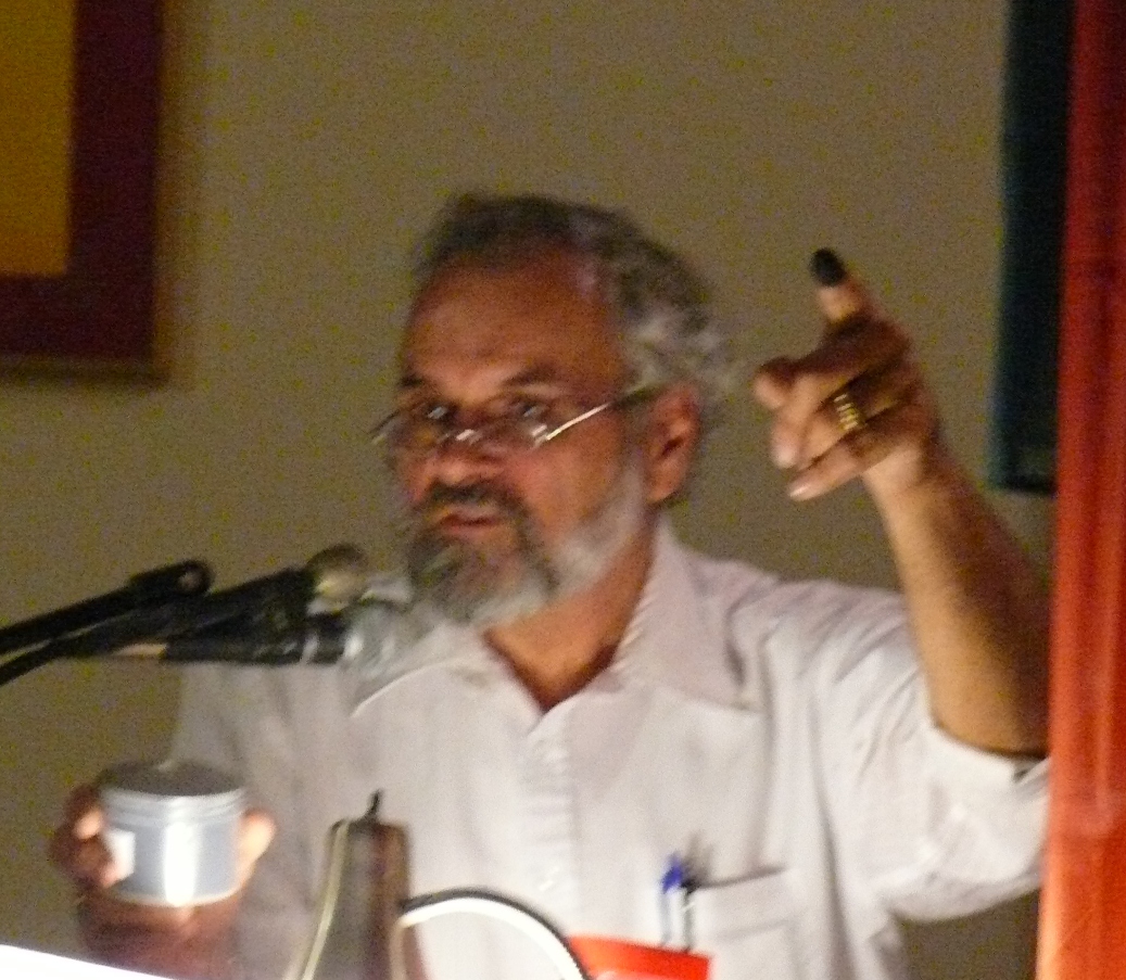 Paul Chakroff of St. Croix Environmental Association demonstrates the dustiness of petroleum coke by putting some on his finger.
