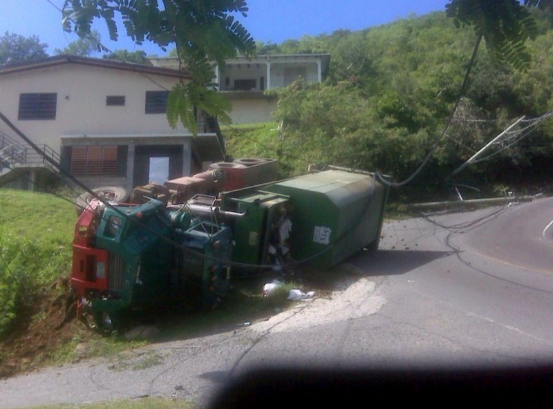The STS truck struck two phone poles on Donkey Hill before overturning. The driver was unhurt according to witnesses.