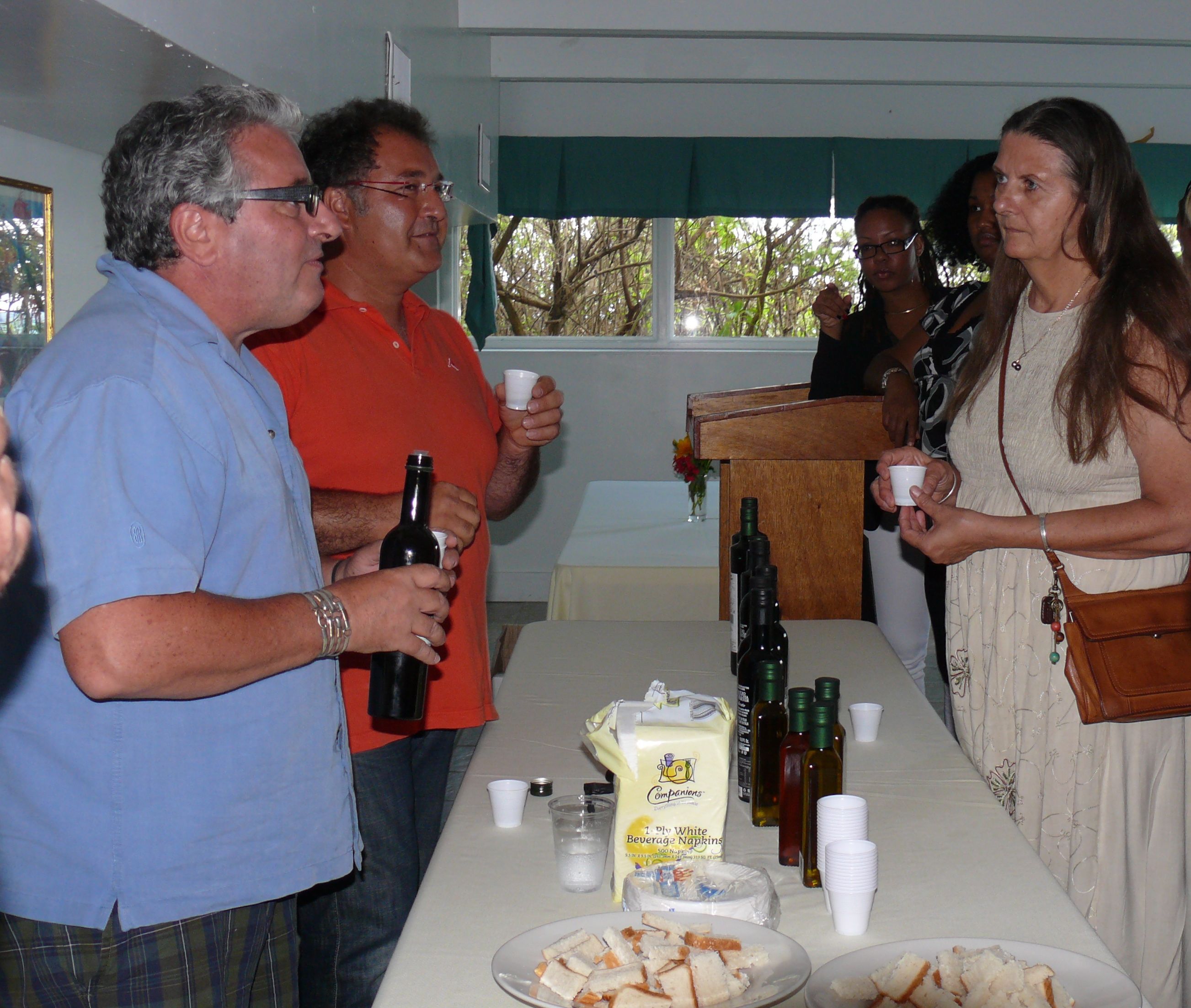Massimiliano Montecchia of the Frantoio Montecchia olive oil company (orange shirt) offers a taste of one of his olive oils, while Pietro Bartocci (blue shirt) talks about the oil's characteristics at Wednesday's St. Croix Food and Wine Experience seminar.