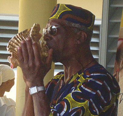 Wilfred "Junie Bomba" Allick Jr. blows a call on the conch.