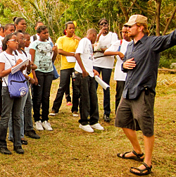 Ridge to Reef Farm Director Nate Olive (right) talks with local science students about the farm's solar-powered irrigation system.