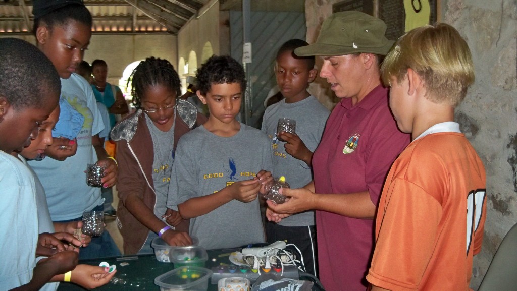 The Department of Agriculture's Jacqueline Kowolski helps students plant seeds.