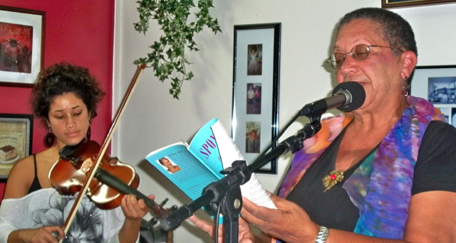 Thahila de Jesus plays viola as Winnie 'Oyoko' Loving reads a poem.