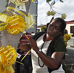 Shirmel Gumbs-Heyliger ties a ribbon for Dwayne Cromwell.