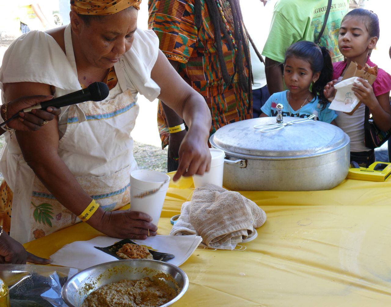 Two young culinarians enjoy a little pasteles while watching Sylvia Ventura demonstrate how they are made Monday afternoon at the V.I. Agrifest.