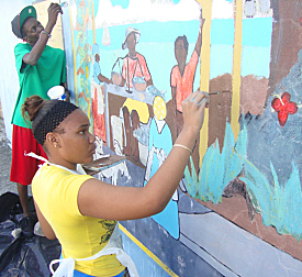 Claynelle Gordon, 15, (front) and Shakir Smith, 16, restore the mural at the Caribbean Center Museum of the Arts in Frederiksted.
