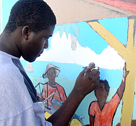Jason Peter, 17, carefully touches up a cloud on the mural.
