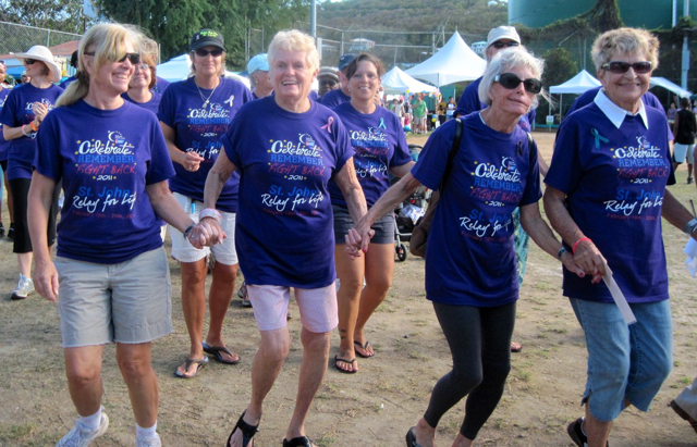 From left, Karla Shatzer, Lee Morris, Elaine Estern and Beverly Biziewski hold hands as the Relay for Life gets under way.