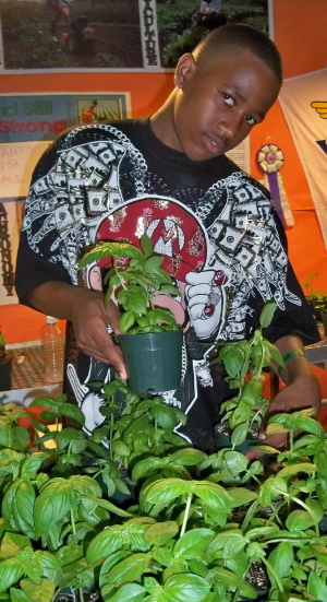Ajahni Matthis, a seventh grader at John H. Woodson Junior High, sells basil at the school's booth.