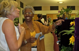 Stephanie Fletcher (left) gets orchid tips from Magda Finch.