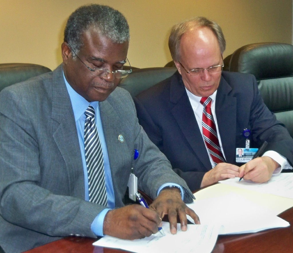 Hospital board chair Valdemar Hill (left) and newly appointed CEO Jeffrey Nelson during signing ceremony.