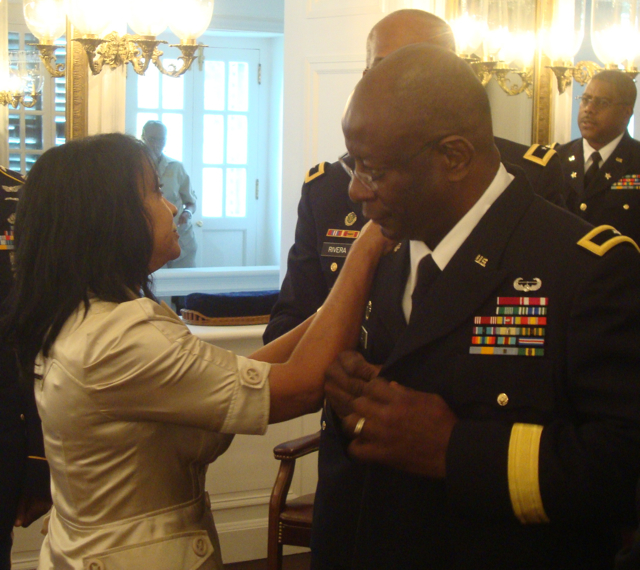 Janice Lewis adjusts the new stars on husband Elton Lewis' jacket.