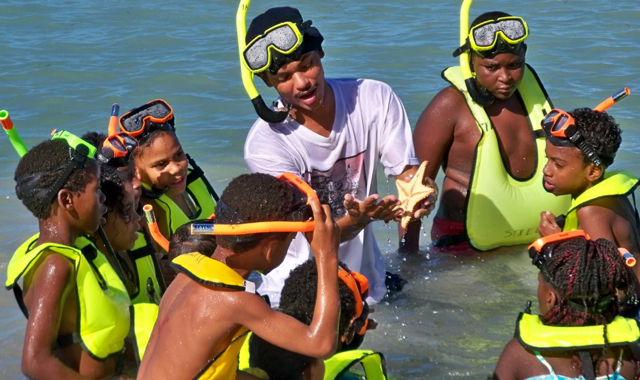 Damien Francis White shows a starfish to Beyond Vision students at South Gate Nature Preserve Saturday.