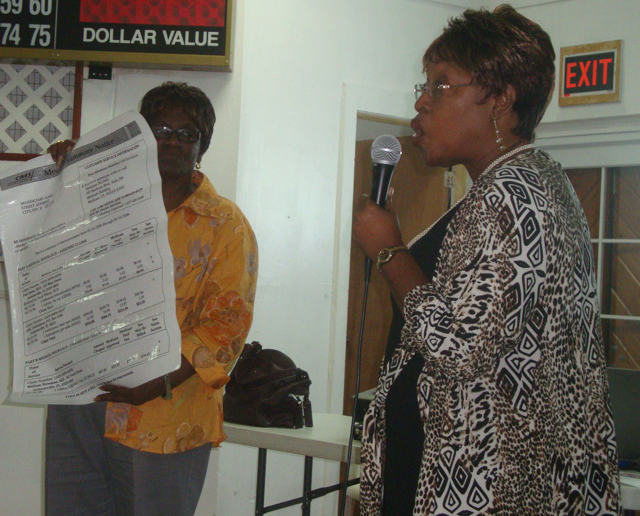 Faustina Richardson holds an enlarged sample of an individual's Medicare report while Annie Day Henry explains how to use it to combat fraud.