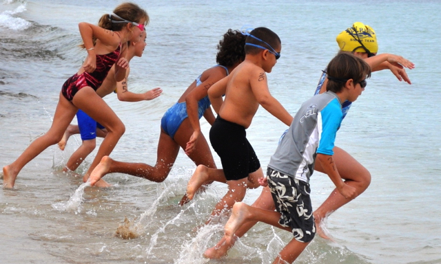 The 7-8 year old age group dives in for the 50 meter swim of their triathlon.