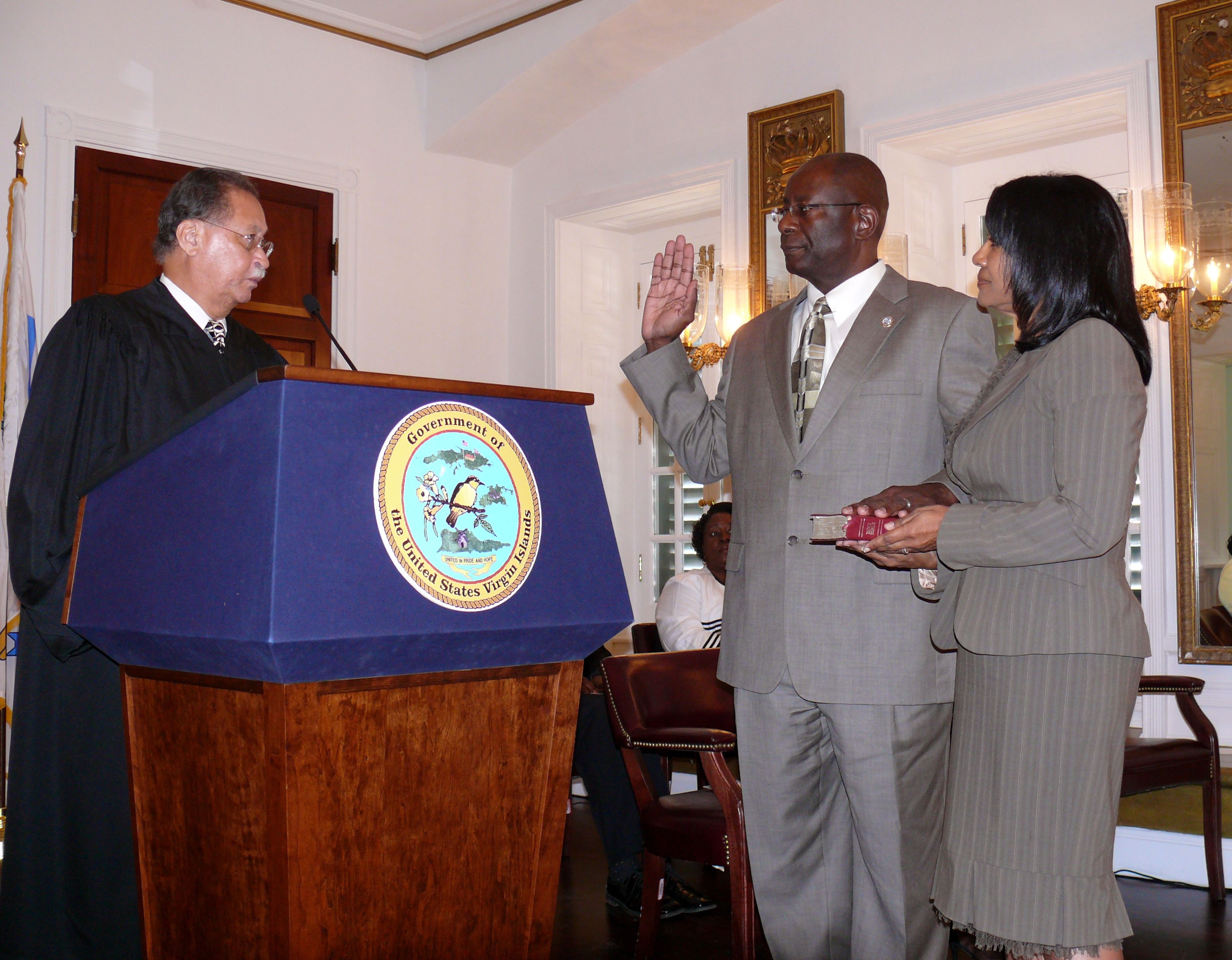 V.I. Superior Court Judge Julio Brady gives the oath of office to Elton Lewis while Lewis' wife, Janice, holds the Bible.