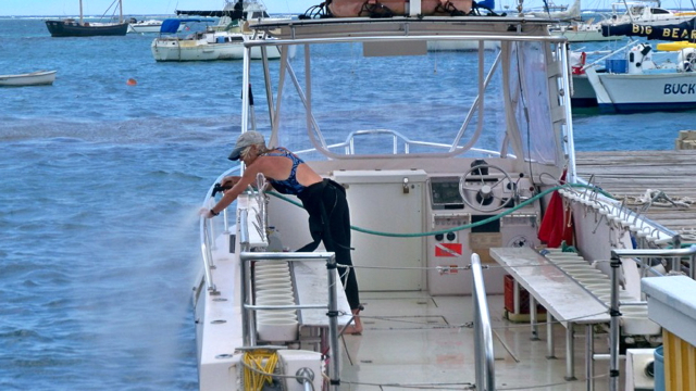 Michelle Pugh hoses off her dive boat. 
