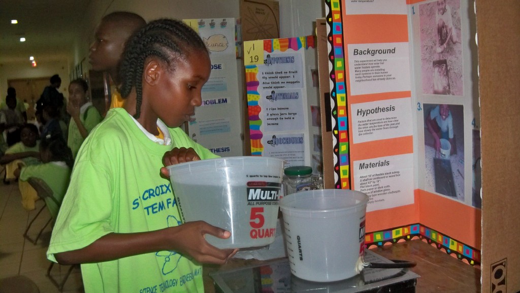 Moajania Denis, fourth-grader at Evelyn Williams Elementary, with his solar water heater.