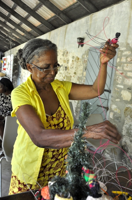 Judy Bain weaves a doll.