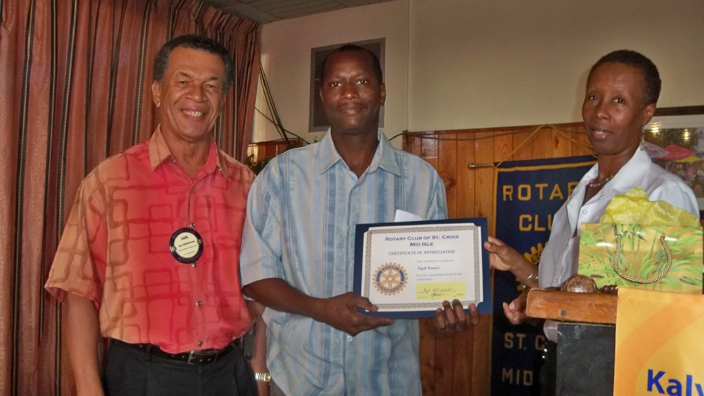Skyline Car Rental's Nigel Francis (center) receives his award from Carl Christensen (left) and Claudia Carrington, Rotary vocational service chairperson.