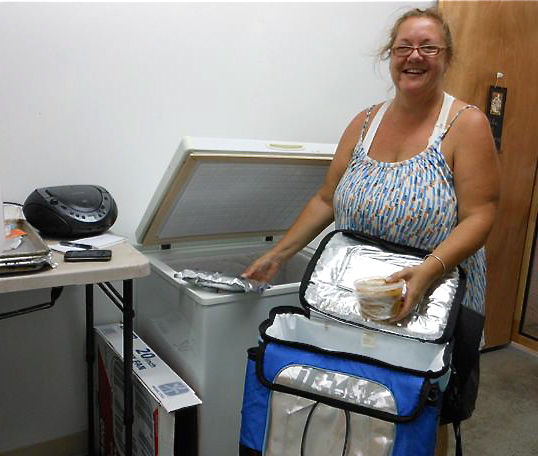 Kat Cashi wheels a cooler through her kitchen to show how it all flows together.